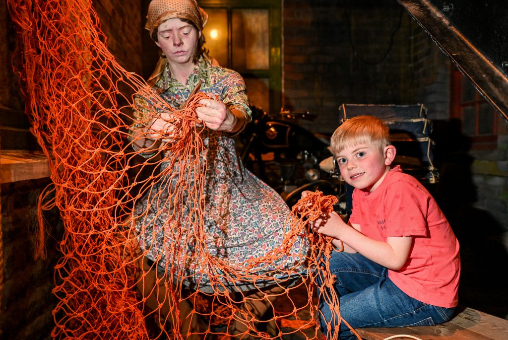 A young boy enjoys playing with the net inside the main attraction at Grimsby Fishing Heritage